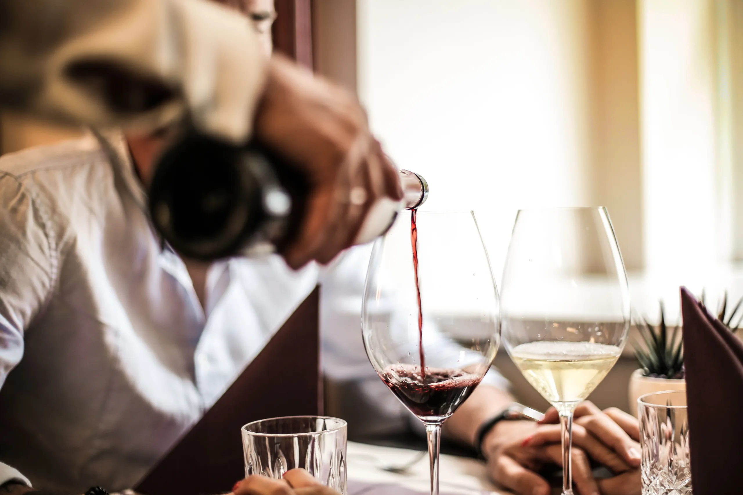 Wine being poured at a restaurant table
